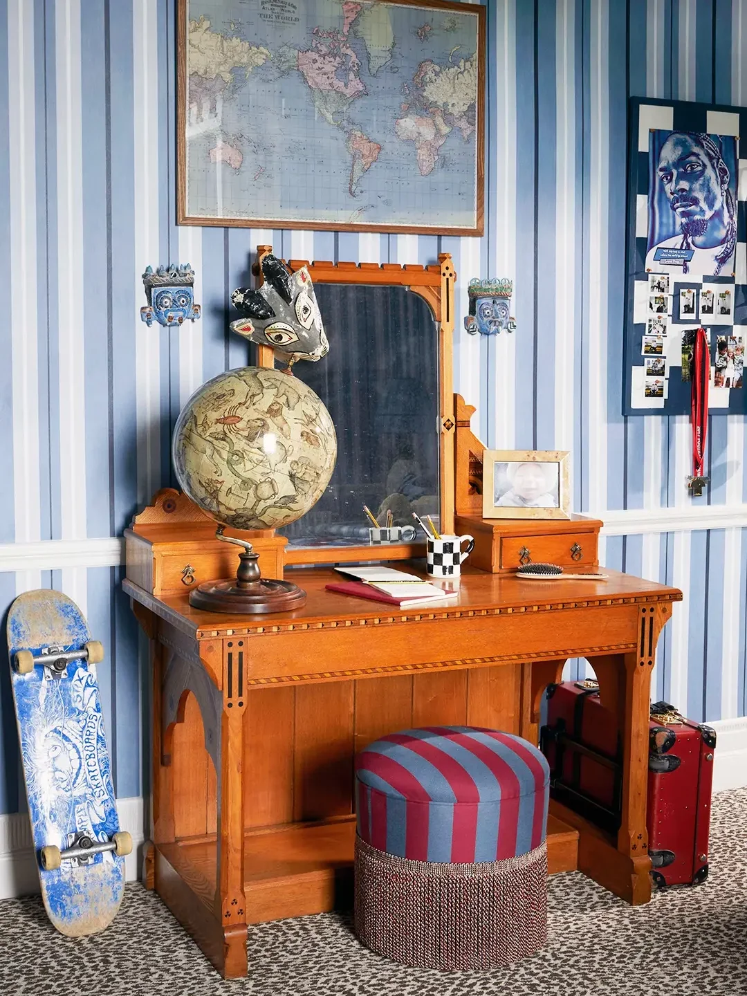 Teen bedroom with blue striped wallpaper and wood desk with striped blue and burgundy stool.