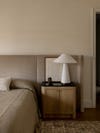 Bedroom with pebble colored walls and a white lamp on nightstand