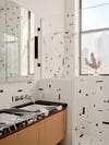 Bathroom with black and white abstract tile and stone vanity. 