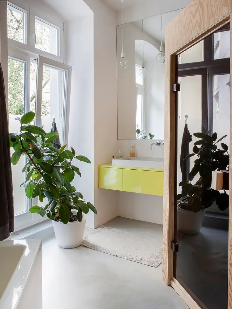 All-white bathroom with neon yellow vanity and wood sauna.