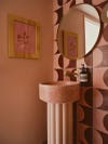 All-pink small bathroom with pink pedestal sink.