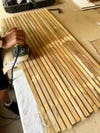 woman sanding wood strips