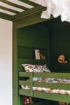 green paneled book nook above bunk bed