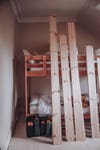 lumber leaning against unpainted bunk bed