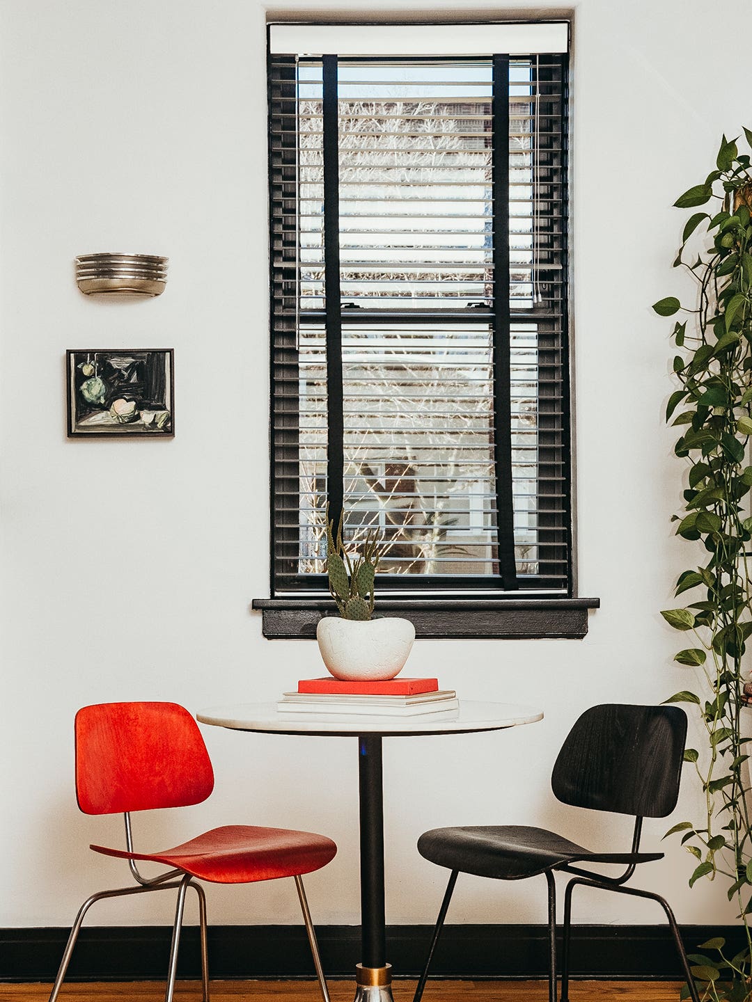Circle table with two chairs next to a window