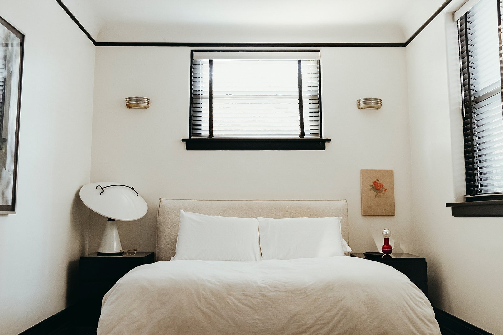 Bedroom with black trim, white walls and white bedding