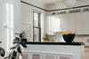 Closeup of kitchen with white cabinets and black countertop