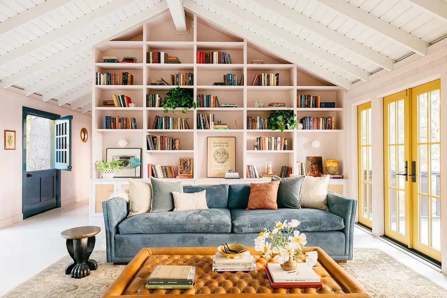 living room with pink wall of bookshelves