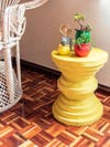 Yellow stool with small potted plants on it