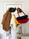 Messy jackets and totes hanging on the back of a door