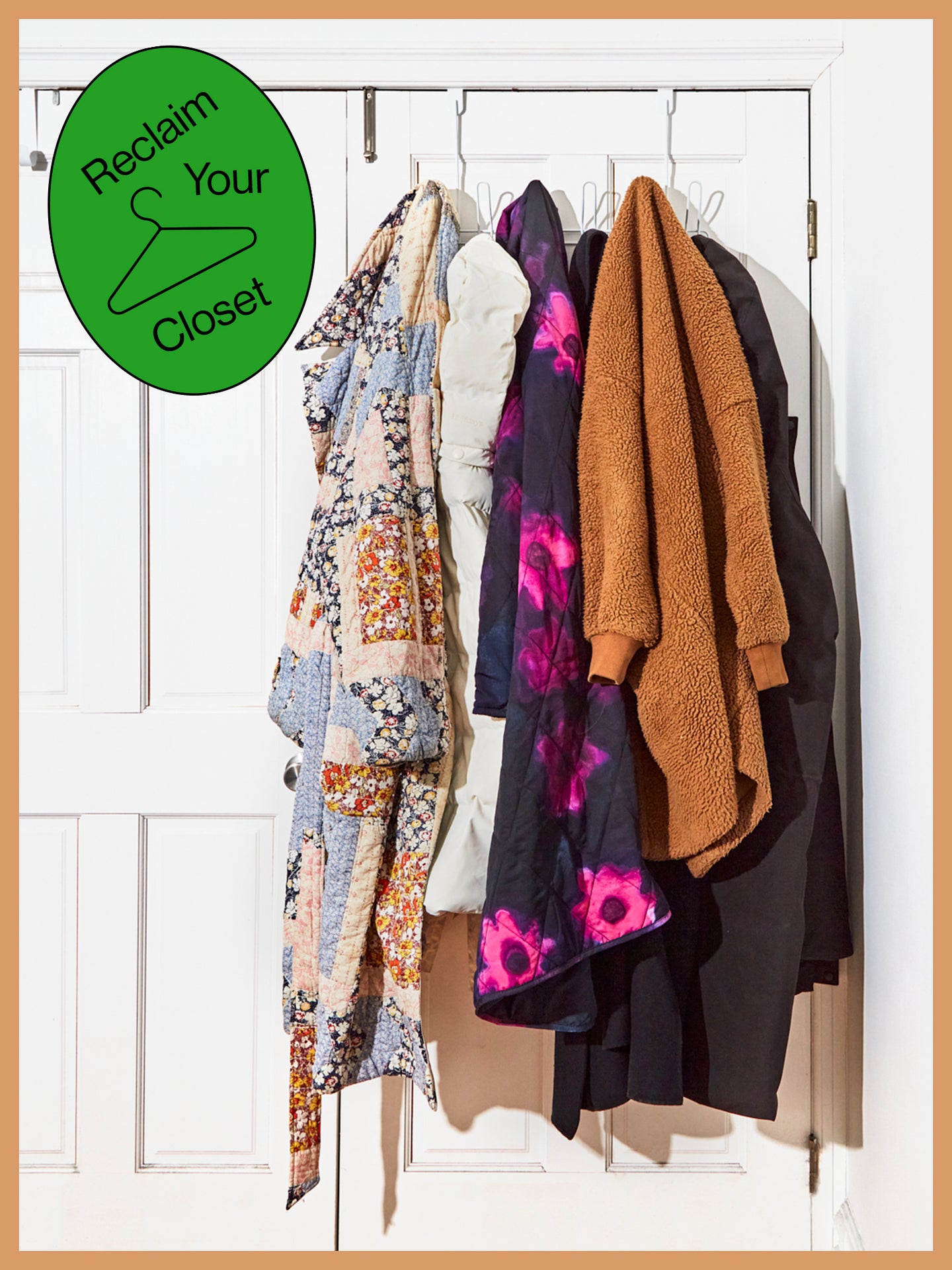 Coats hanging on the back of a door with a sticker that says "Reclaim Your Closet"