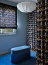 Blue wall and patterned curtain in closet