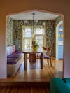 view into dining room with floral wallpaper and yellow trim