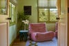 Green sunroom with pink togo chair