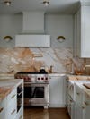 muted green kitchen with gold marble backsplash