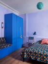 Purple walls in bedroom with blue wardrobe
