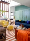 Teal cabinets with blue sofa and yellow chair