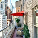 Orange half-circle umbrella on narrow New York City terrace