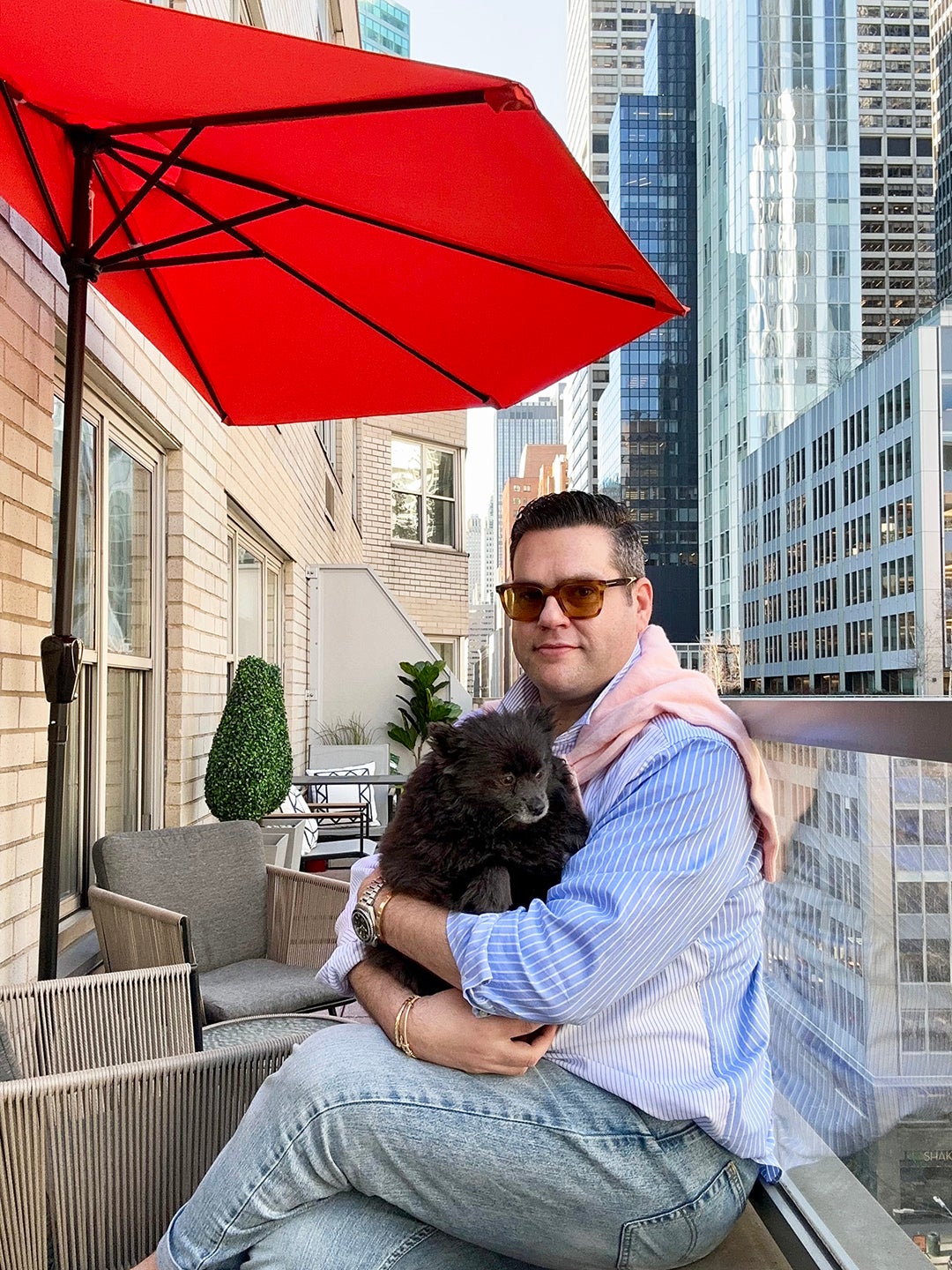 Man holding dog on narrow NYC terrace