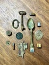 Found objects, like a spoon and coin, on a wooden table