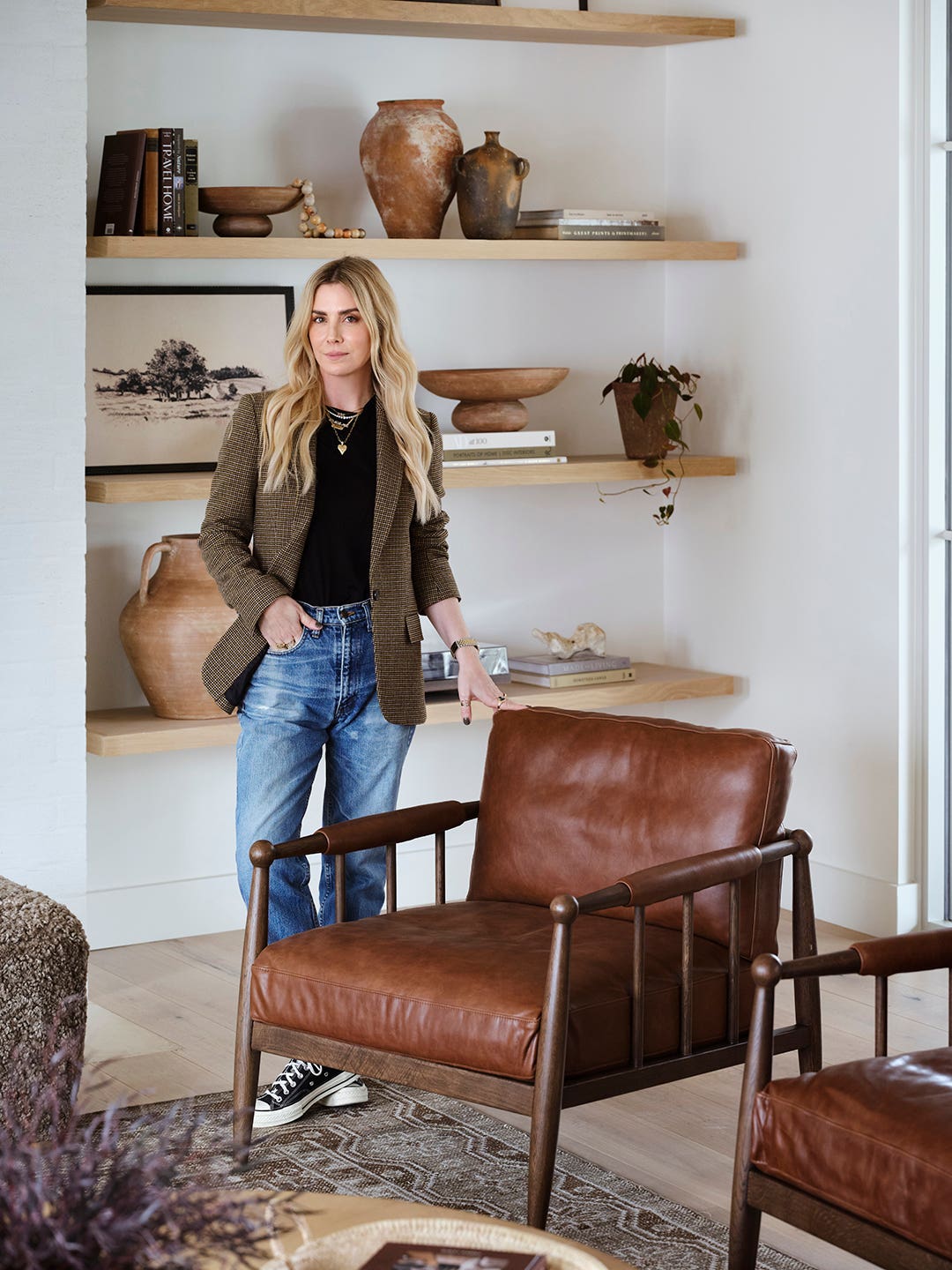woman standing next to leather chair