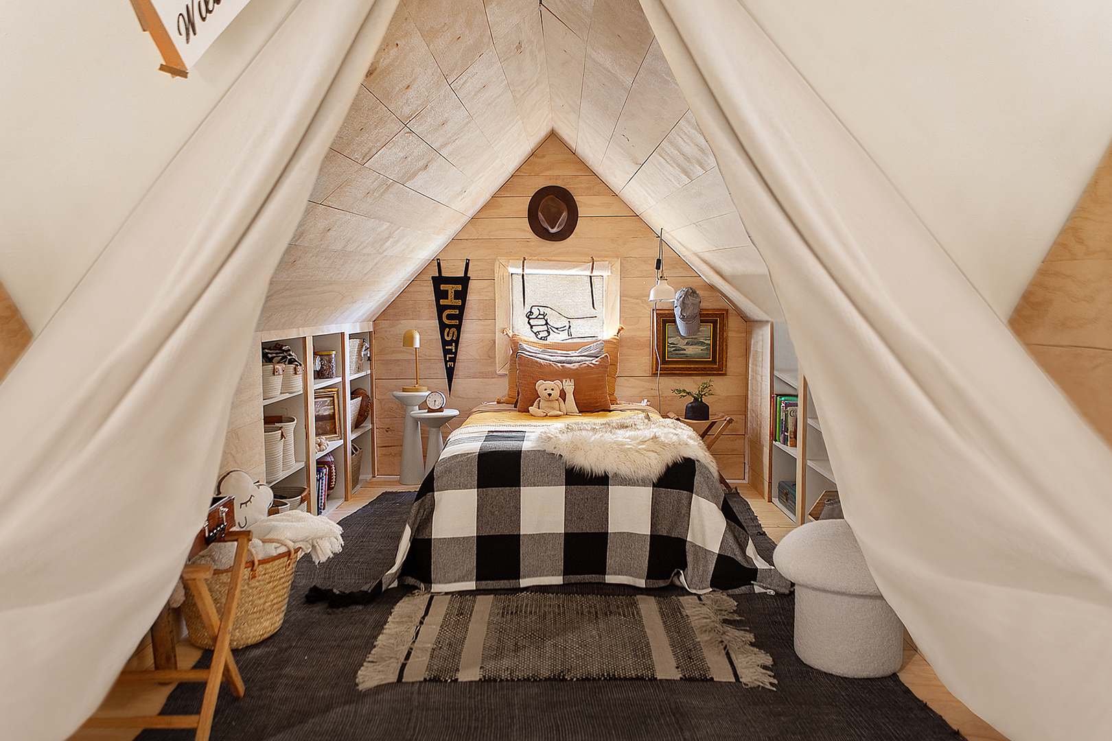 Kid's attic bedroom with wood-lined walls and checkered bedspread.