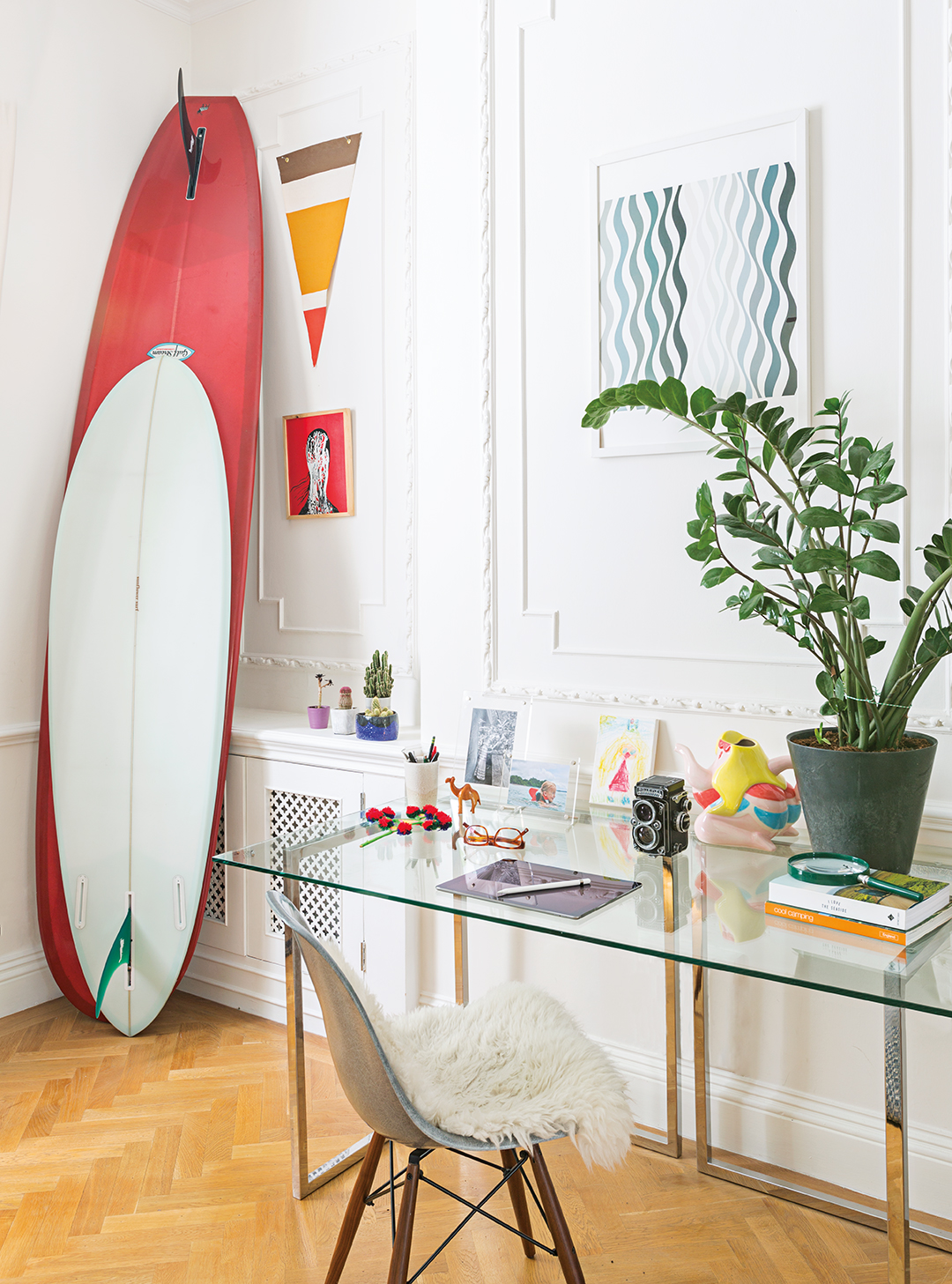 desk area with surfboard against wall