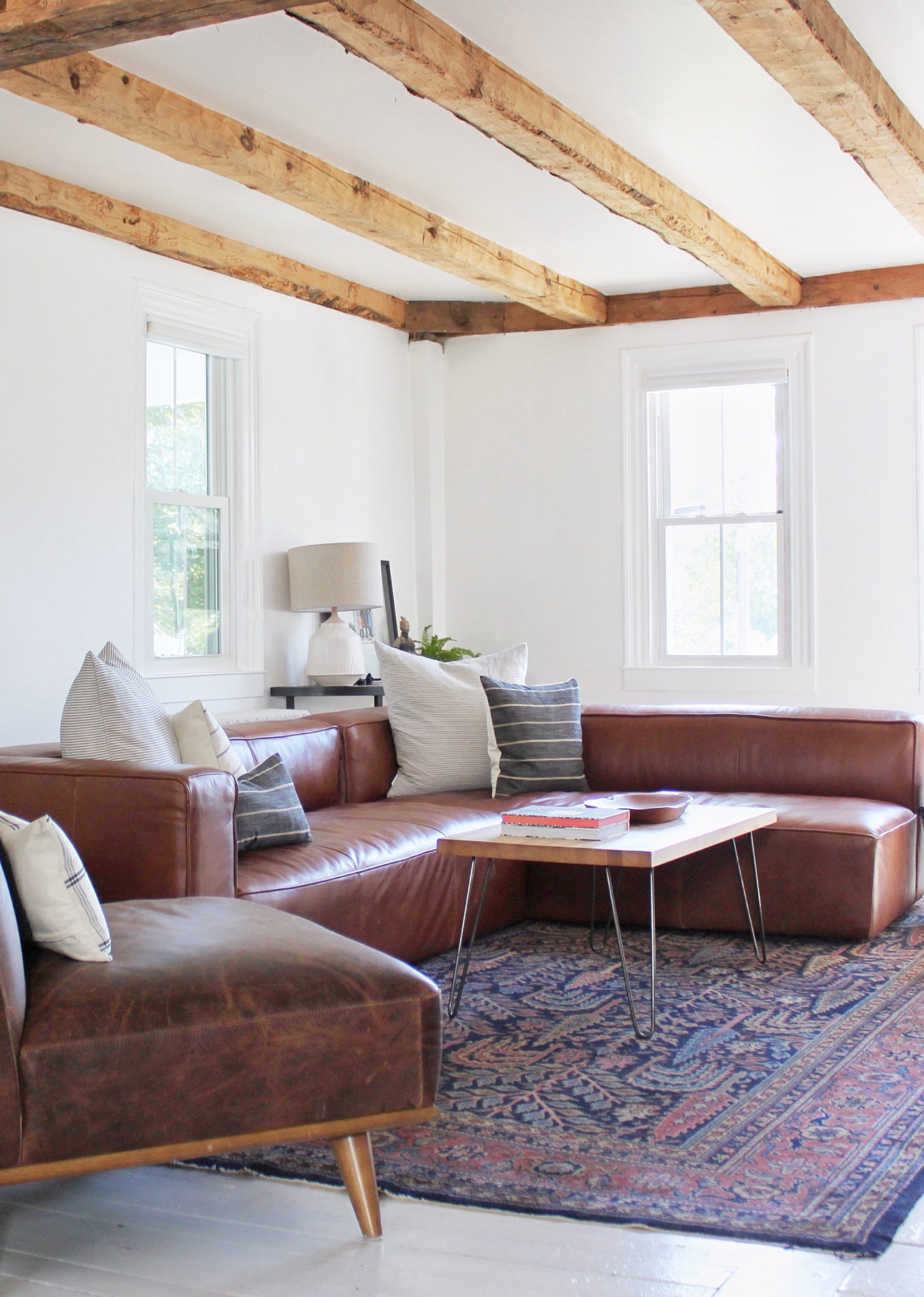 Living room with leather sectional and wood-beamed ceiling