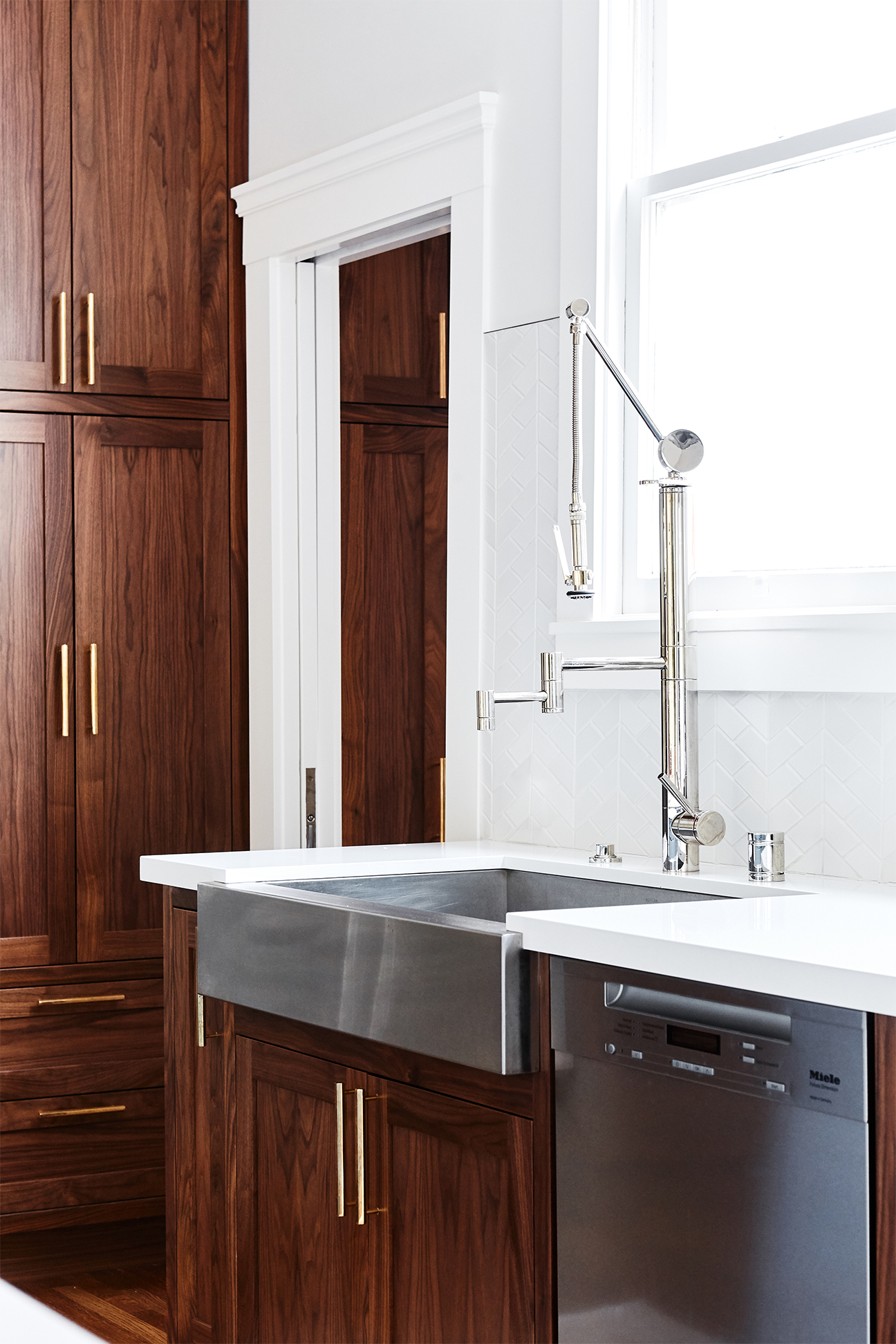 Dark wood cabinets in kitchen with stainless steel sink and dishwasher