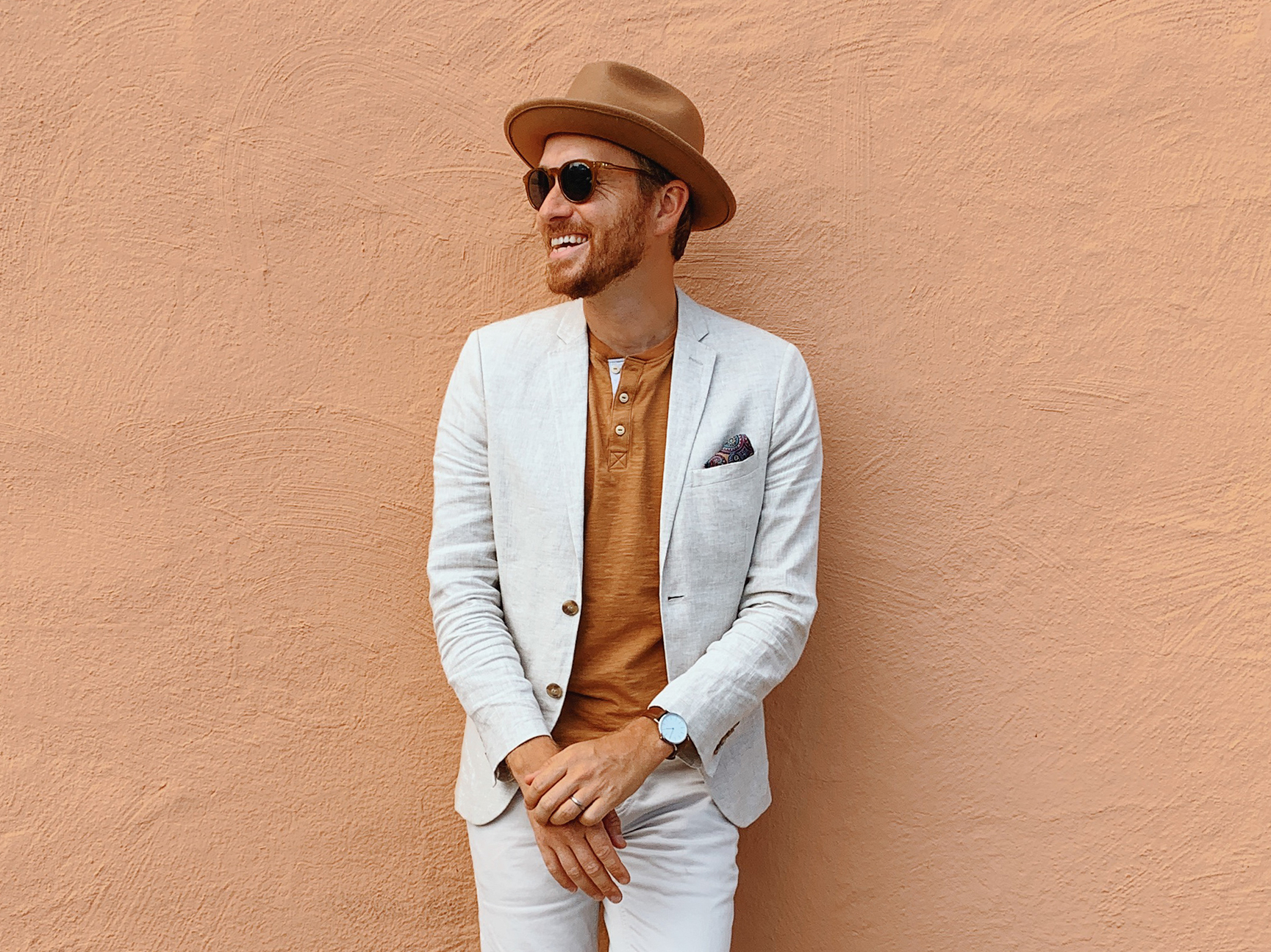 man leaning against a orange wall
