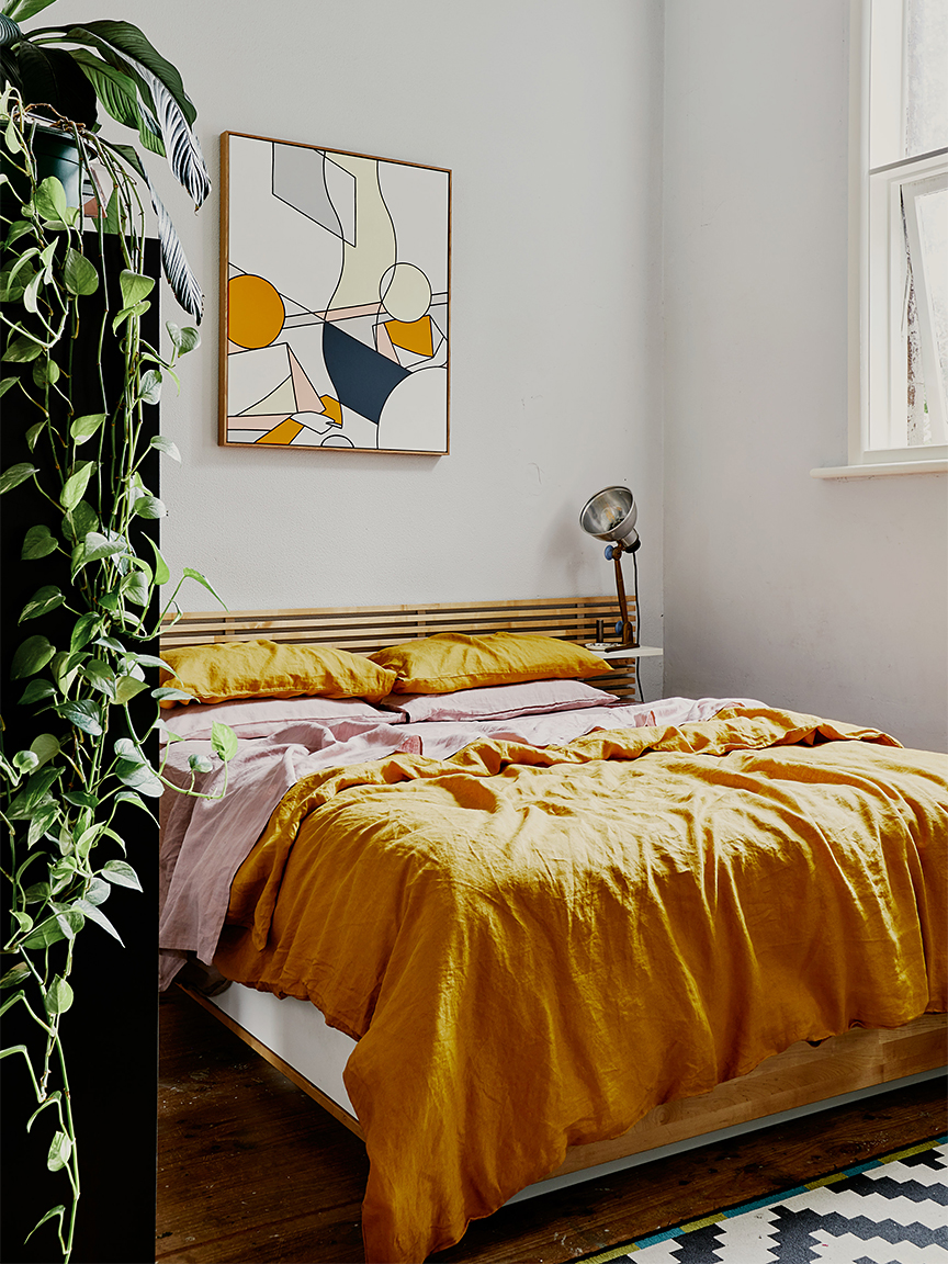 Bedroom with low bed and yellow sheets