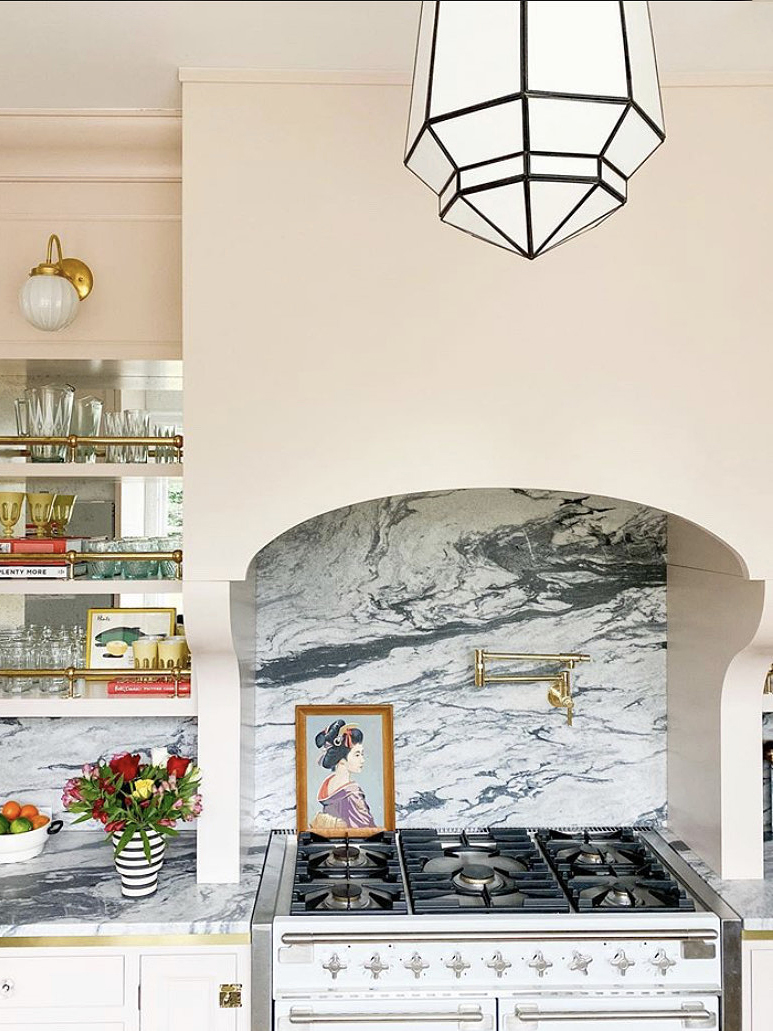 curved range hood with gray stone backsplash