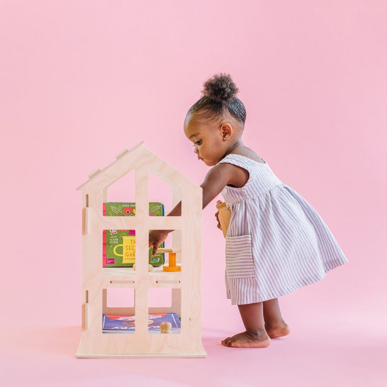  Little girl paying with dollhouse