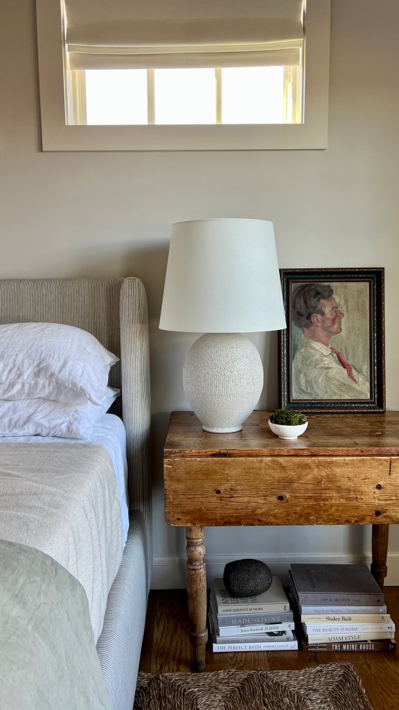 Worn wood side table in greige bedroom