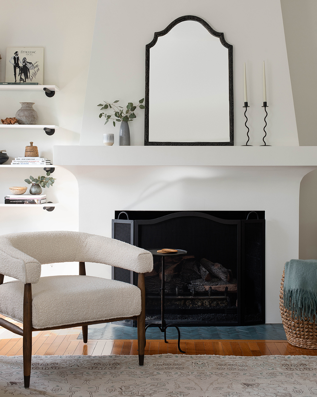 white tapered fireplace with boucle armchair