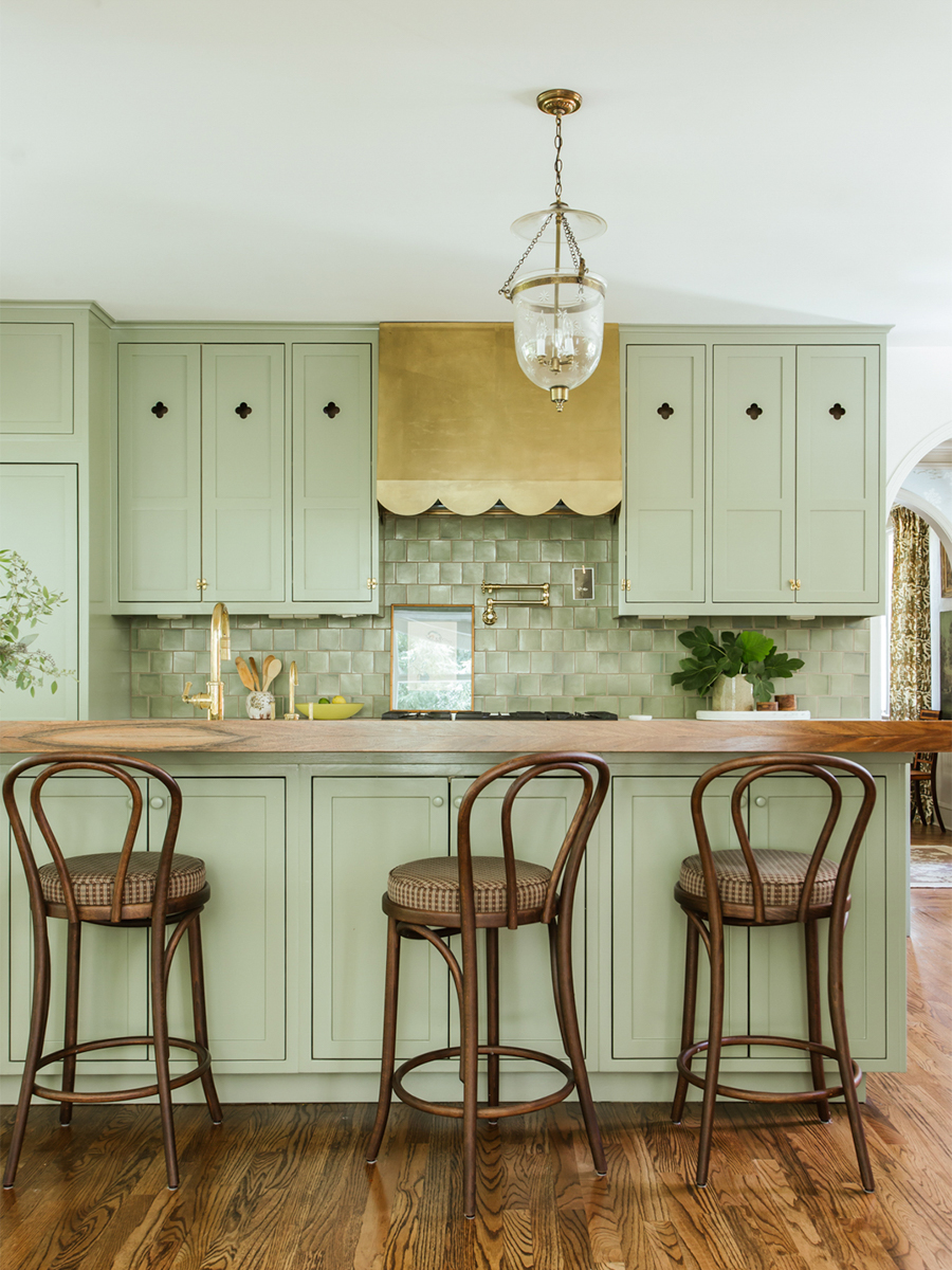 scalloped brass hood in green kitchen