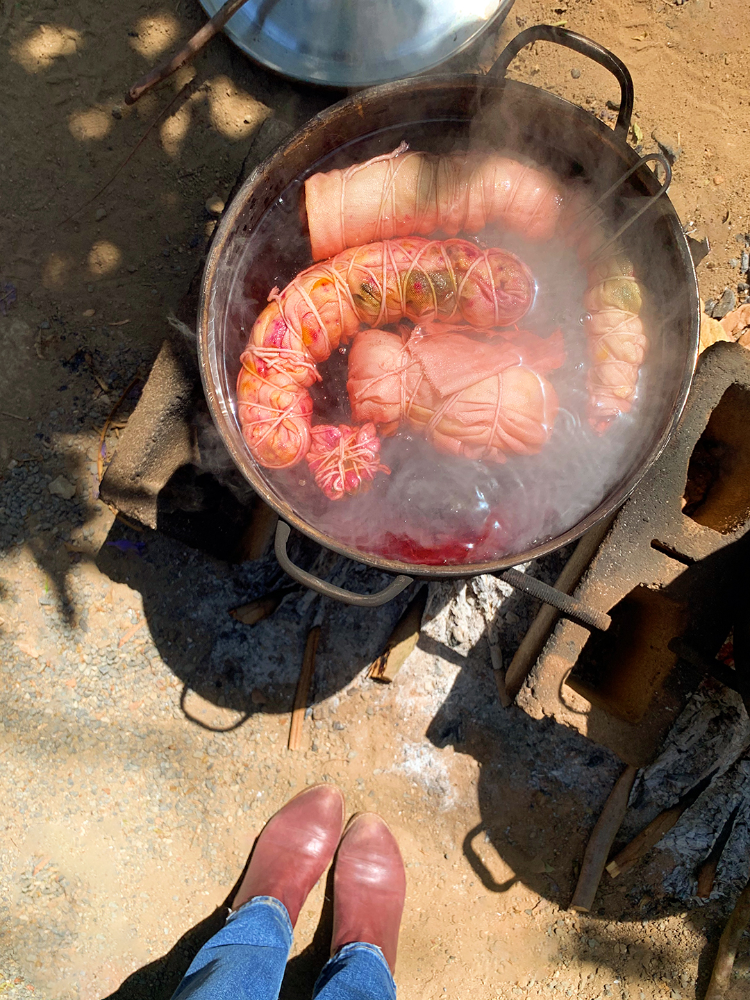 fabric bundles in pot of red dye