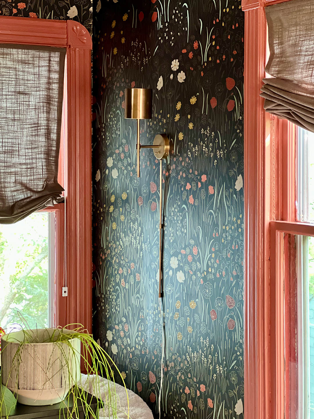 brass sconce on black wallpaper