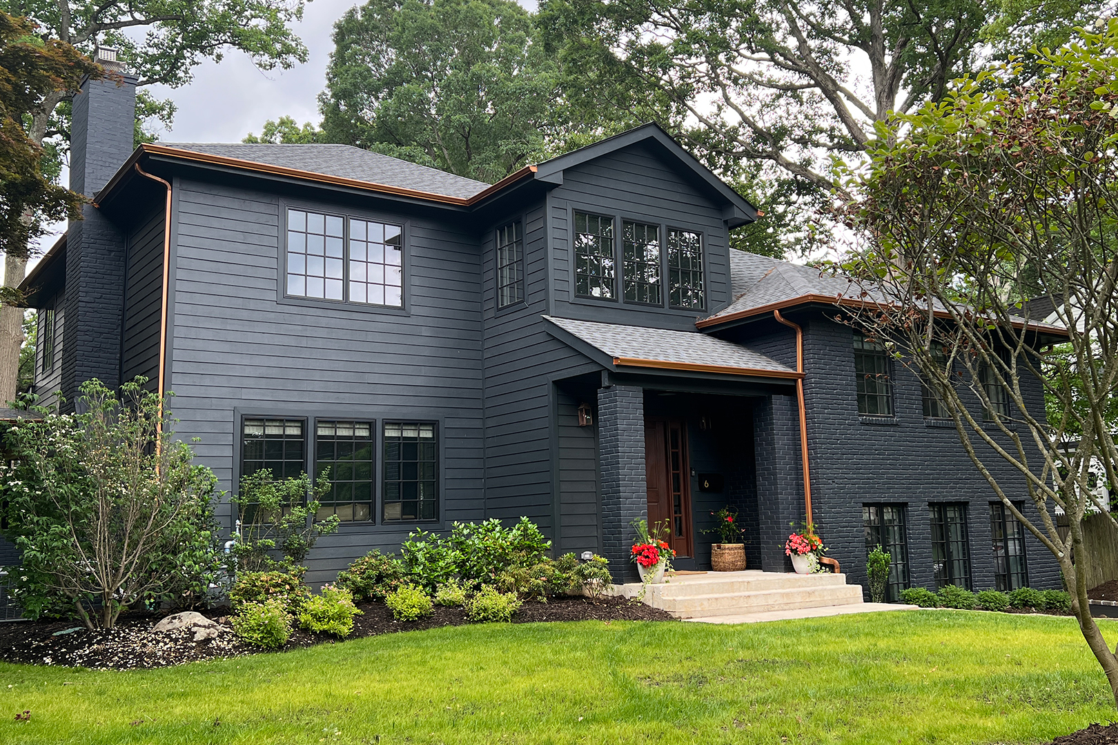 Home with dark exterior and copper gutters