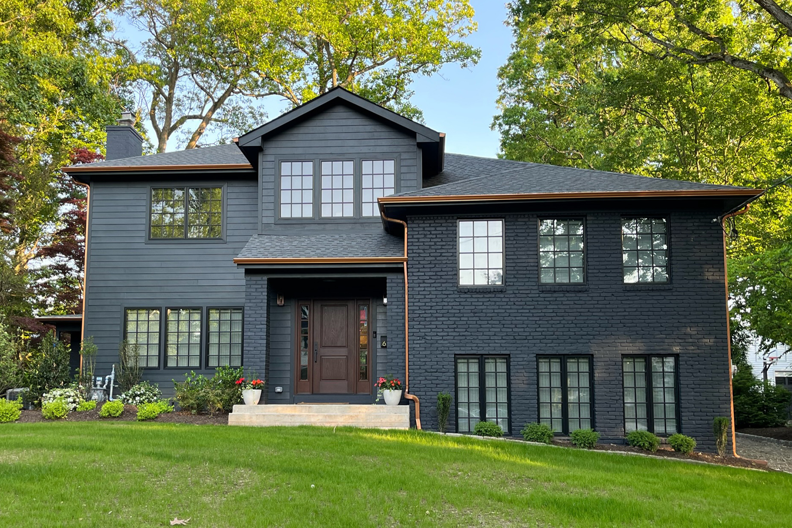Home with dark exterior and copper gutters