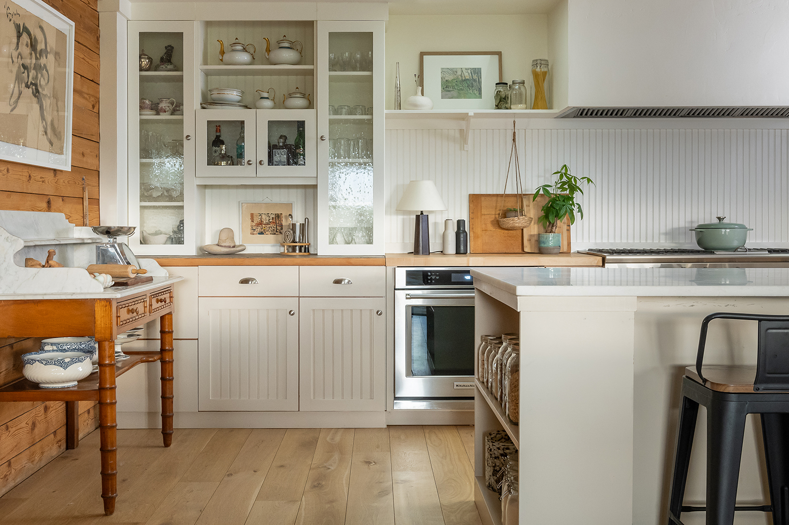 Off white kitchen with beadboard cabinets and backsplash