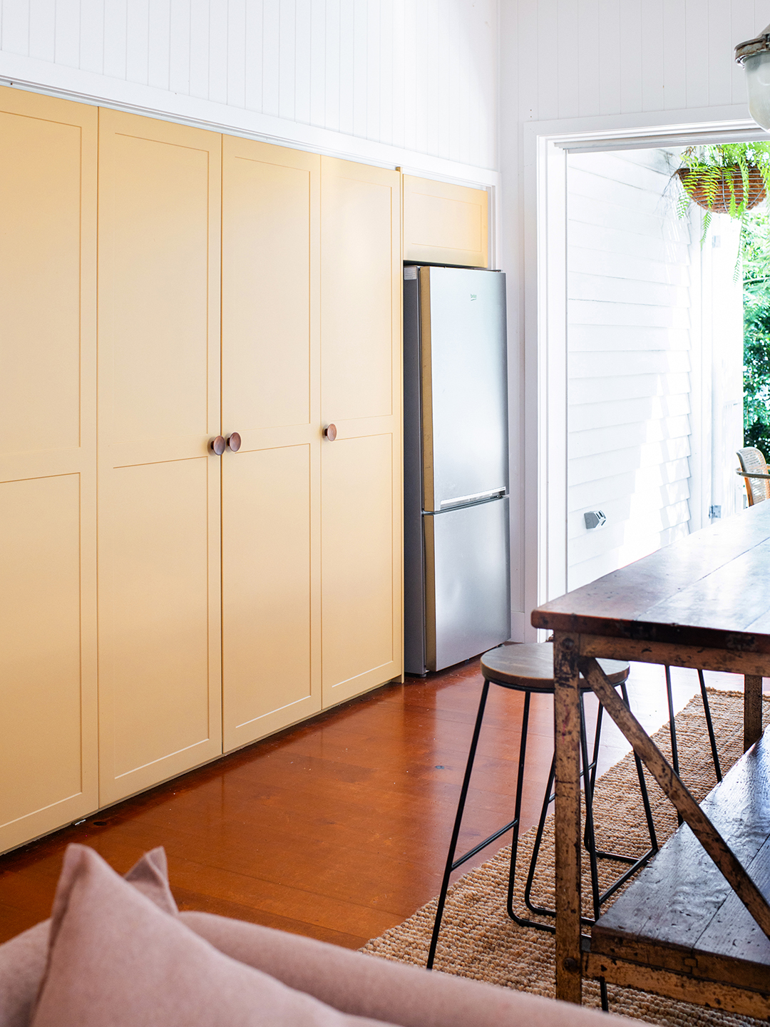 Wall of floor-to-ceiling cabinets painted yellow