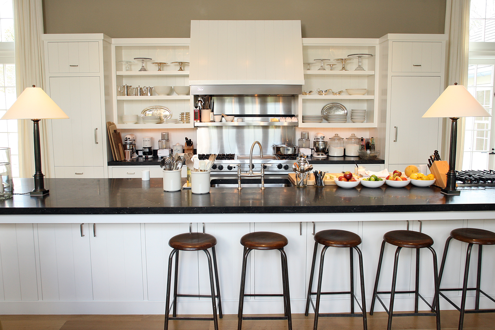 Ina Garden's kitchen with white cabinetry and black countertops