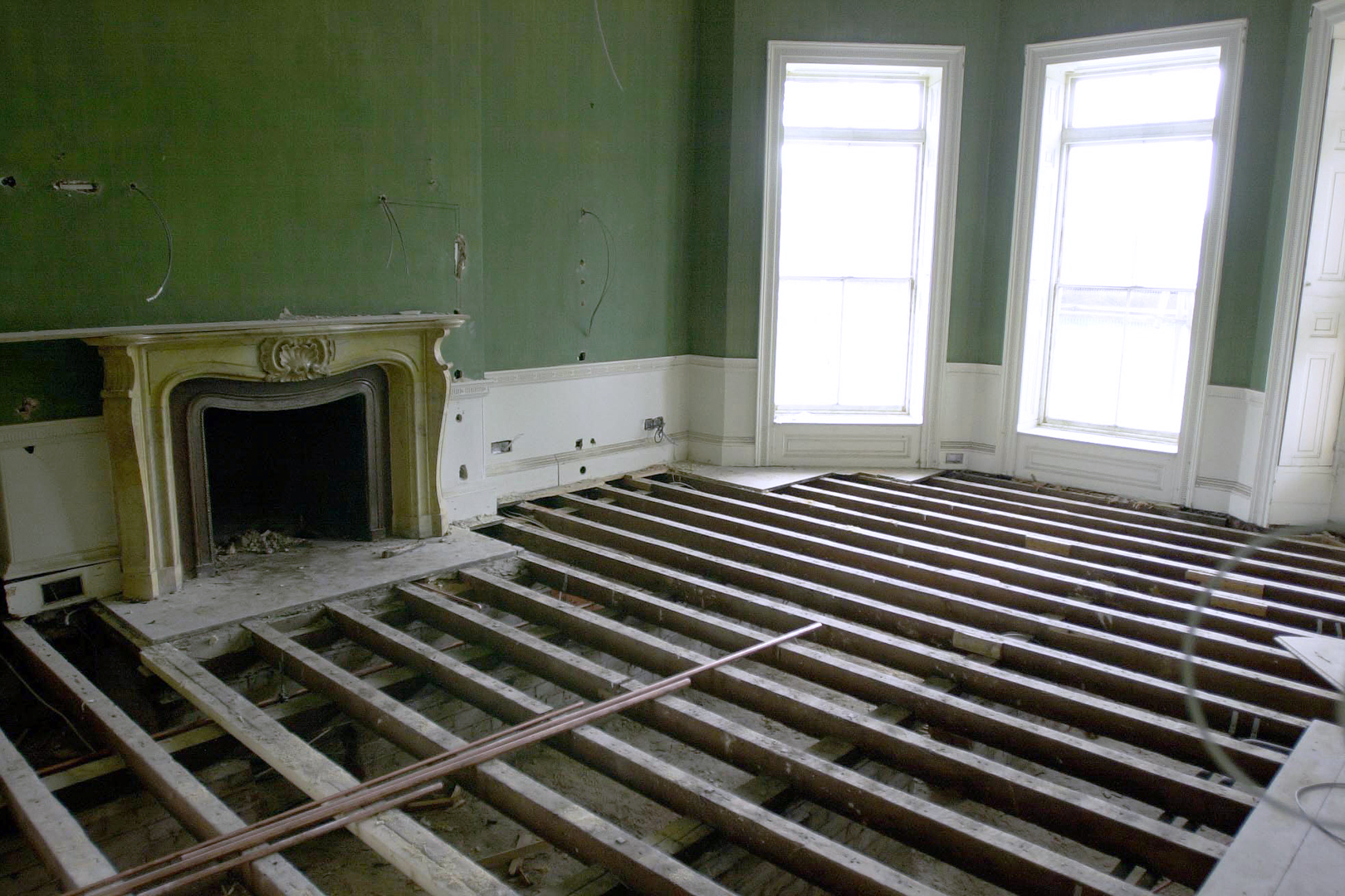 Room with fireplace and floorboards ripped up