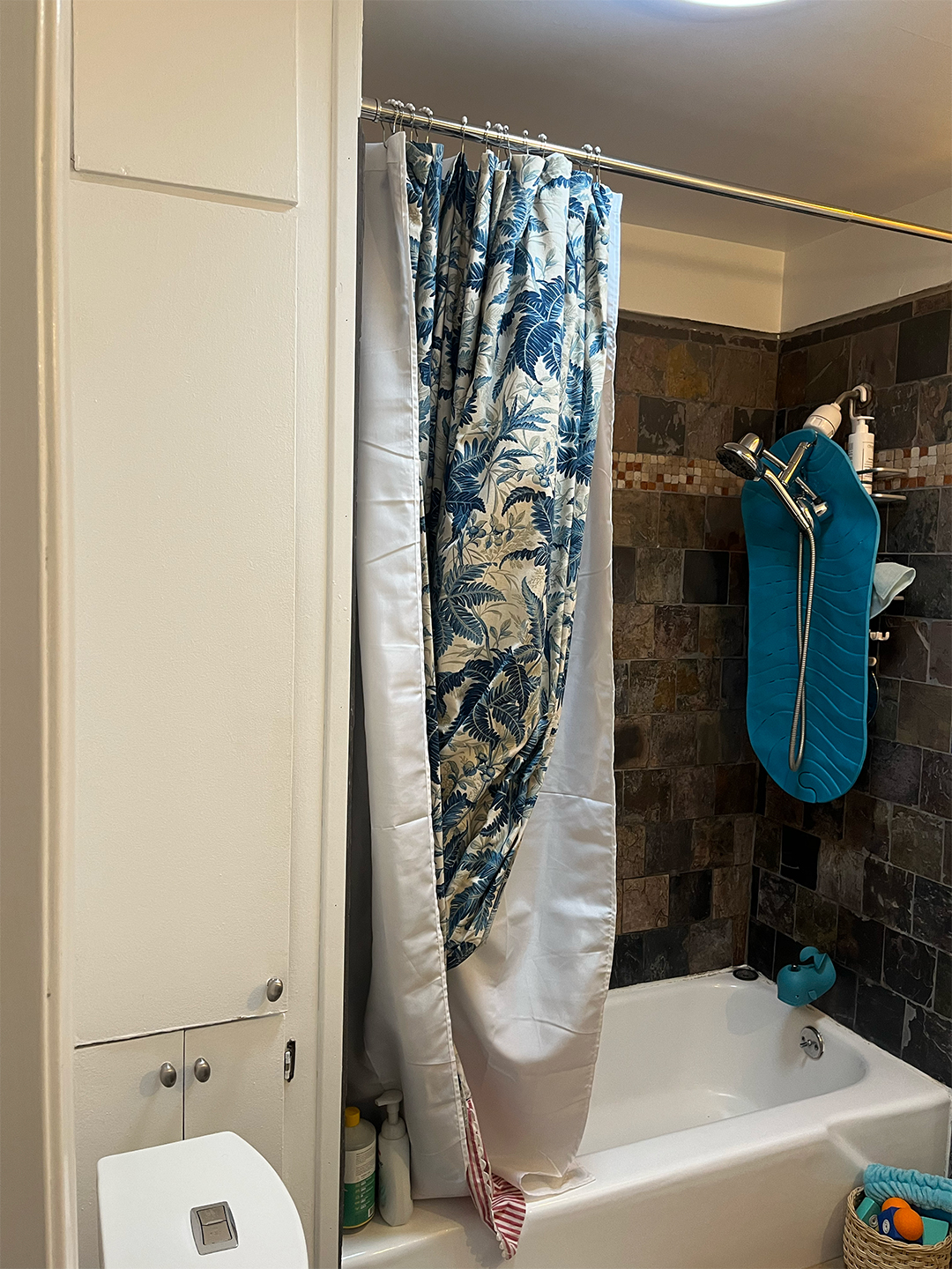 blue shower curtain in dated bathroom