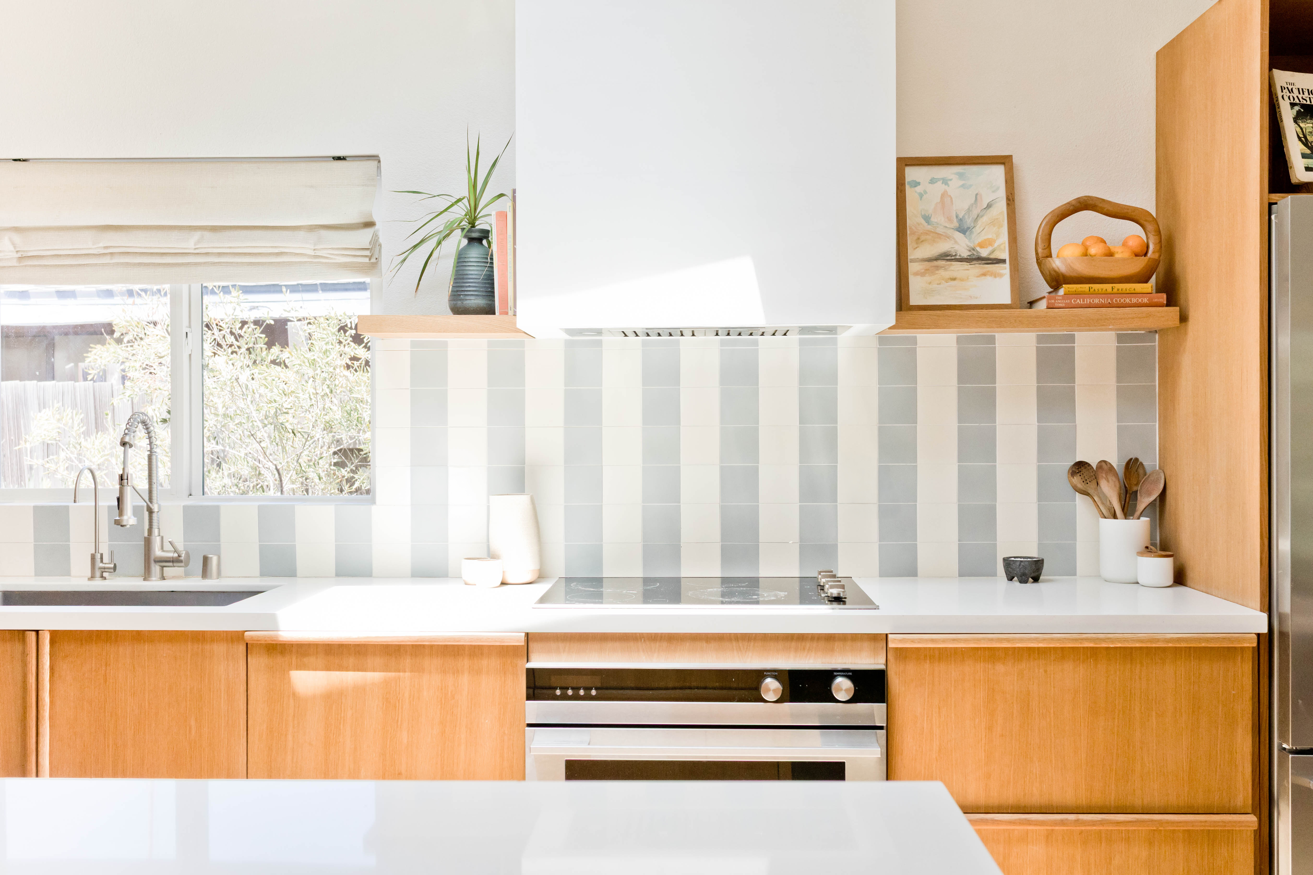 Kitchen with blue and white striped tile and wood cabinetry.