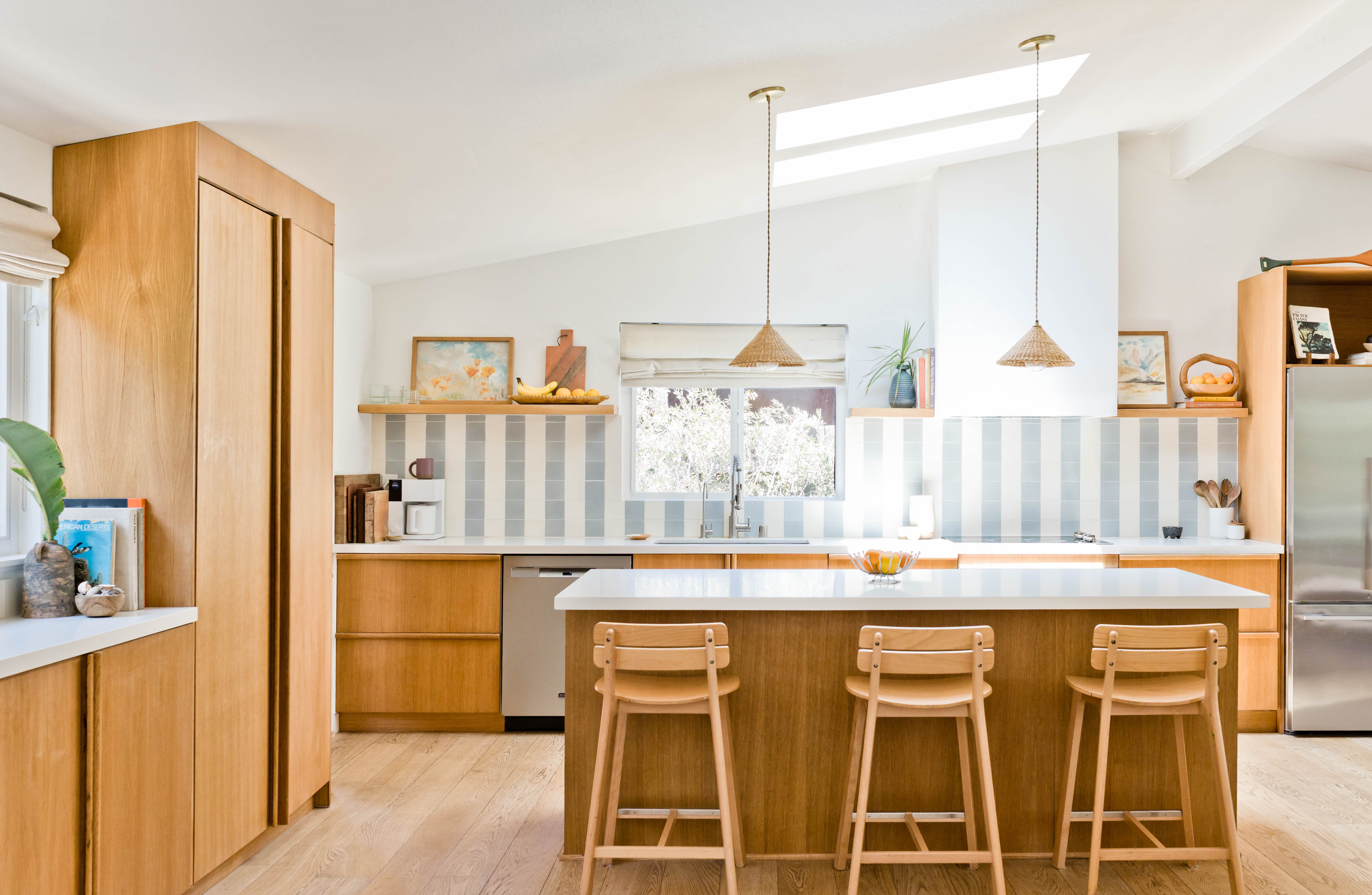 Light-filled kitchen with wood bar and cabinets, and blue-and-white tile.
