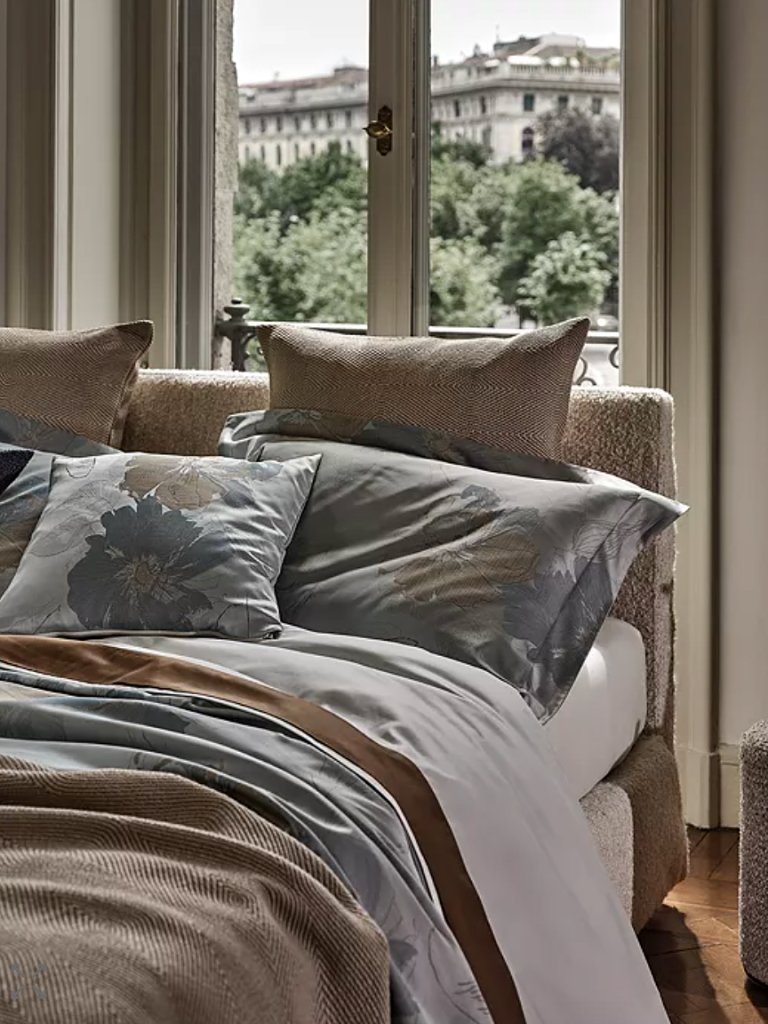 Bed against window with rumpled green sheets.