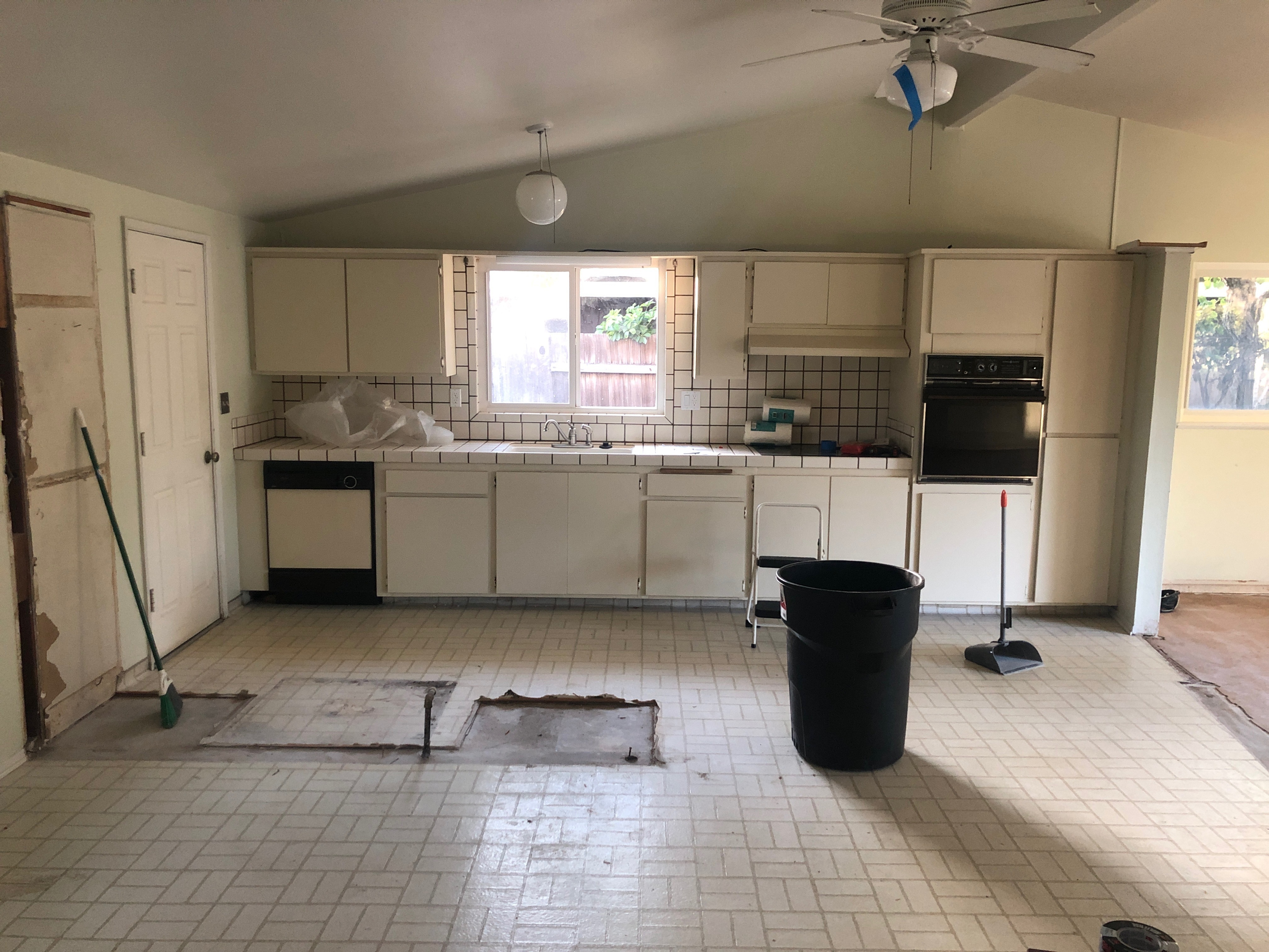 "Before" renovation of kitchen with all-white tile and walls.