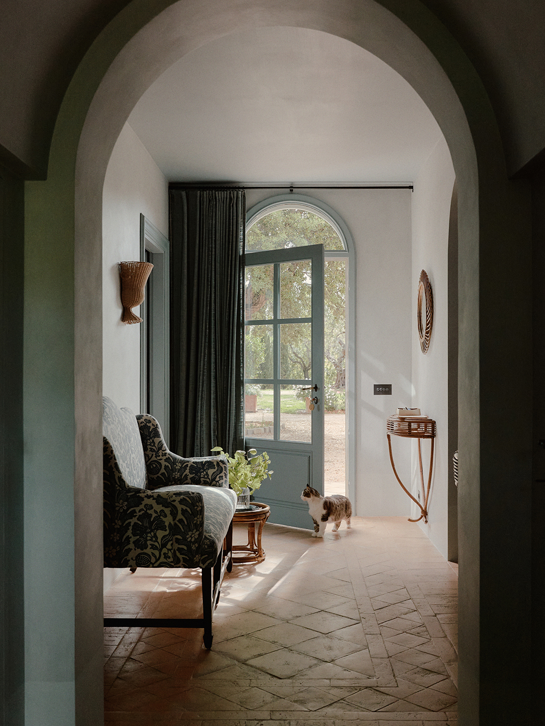 Entrance hall with blue door and patterned settee